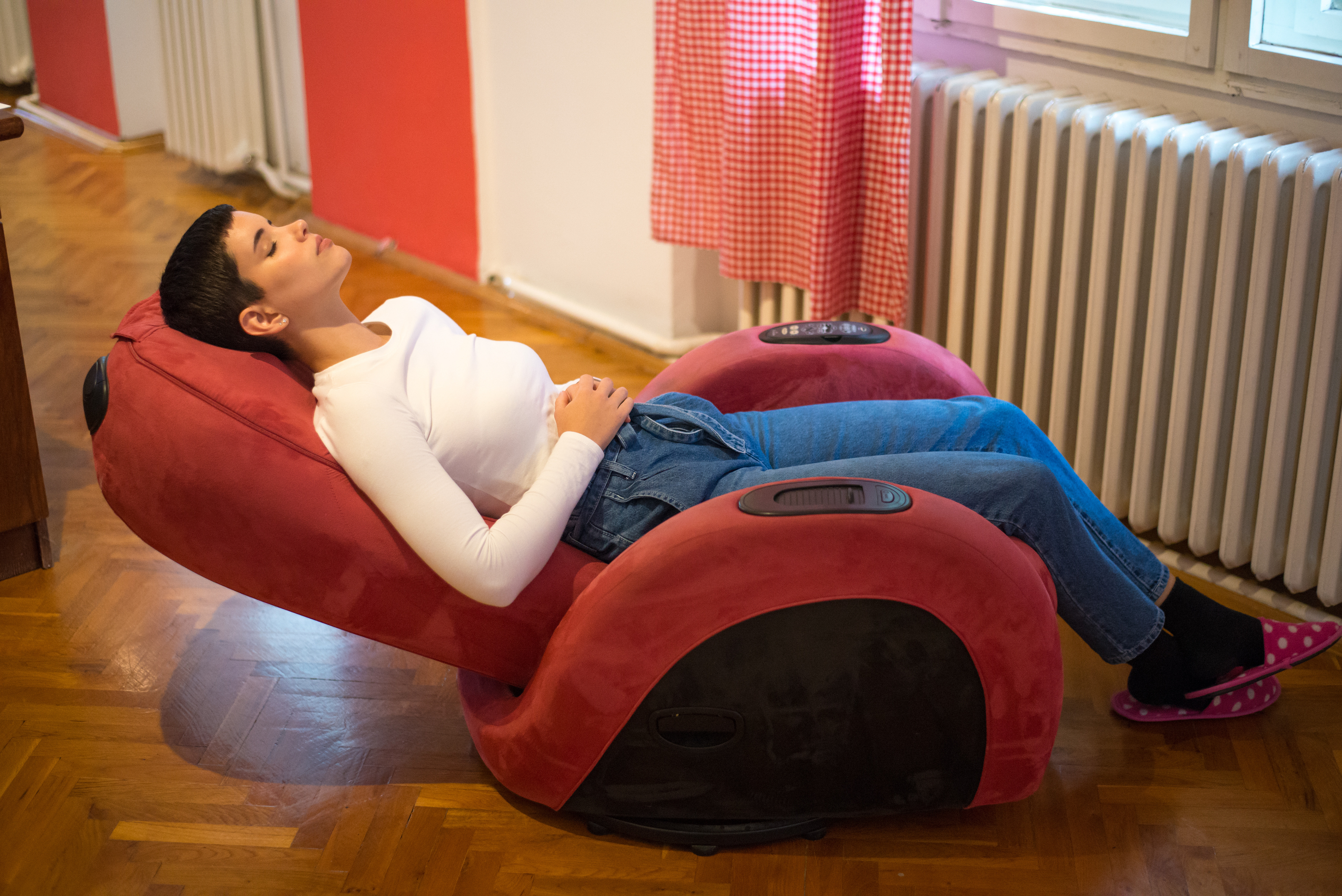 Woman relaxing in a red massage recliner 