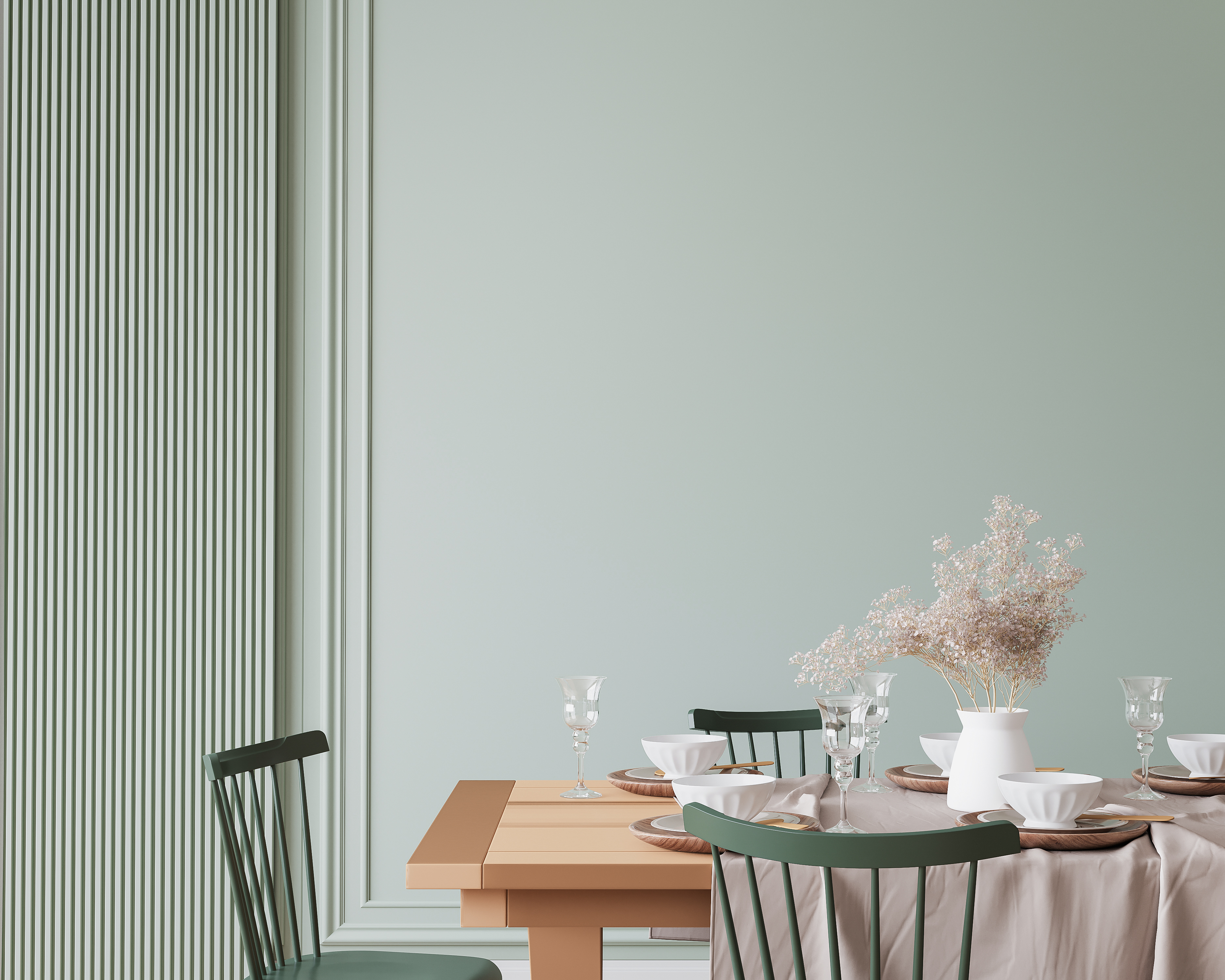 Sage-green dining room with Windsor chairs and a wooden table 