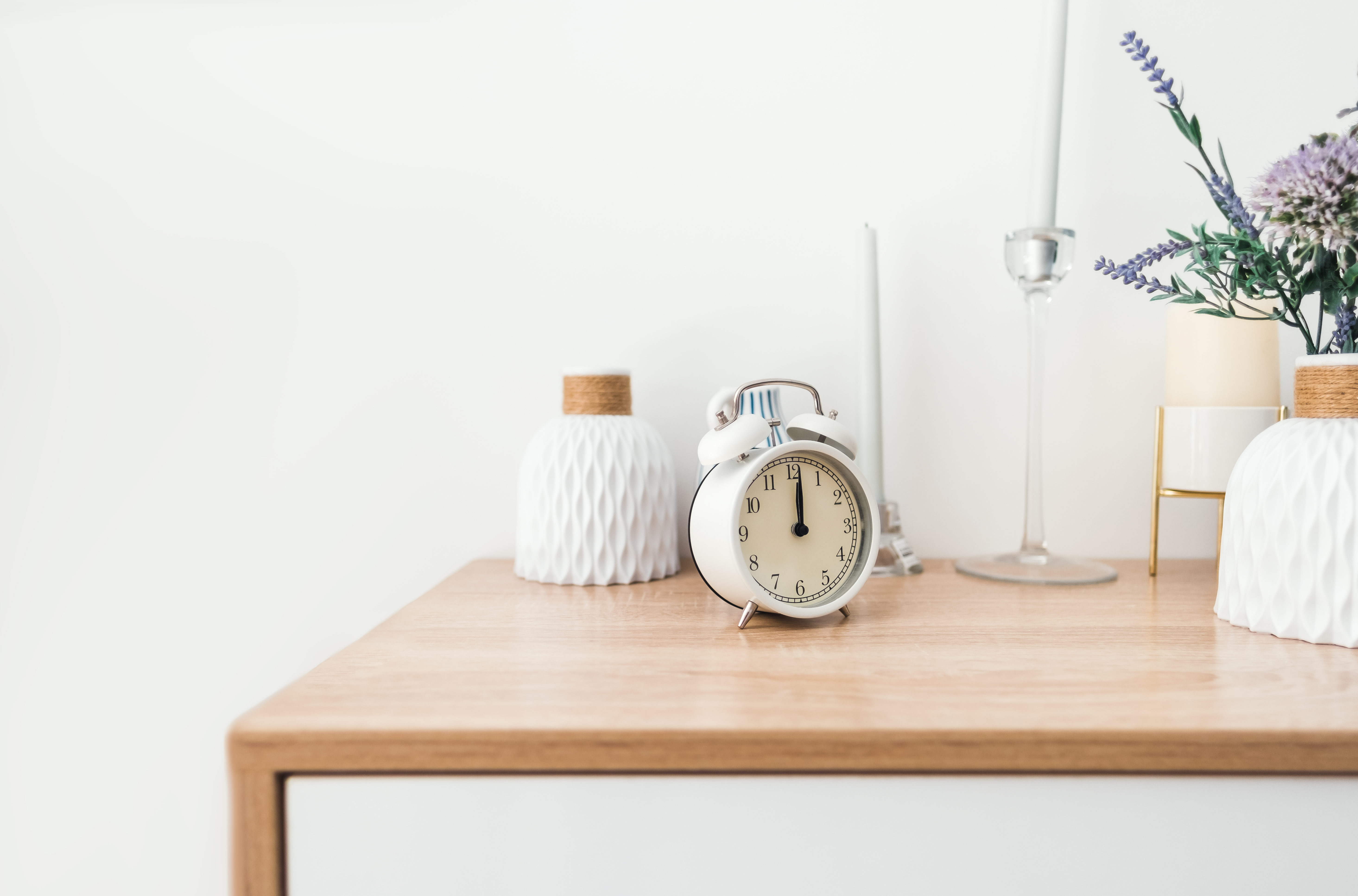: A two-tone nightstand with a clock and other décor 