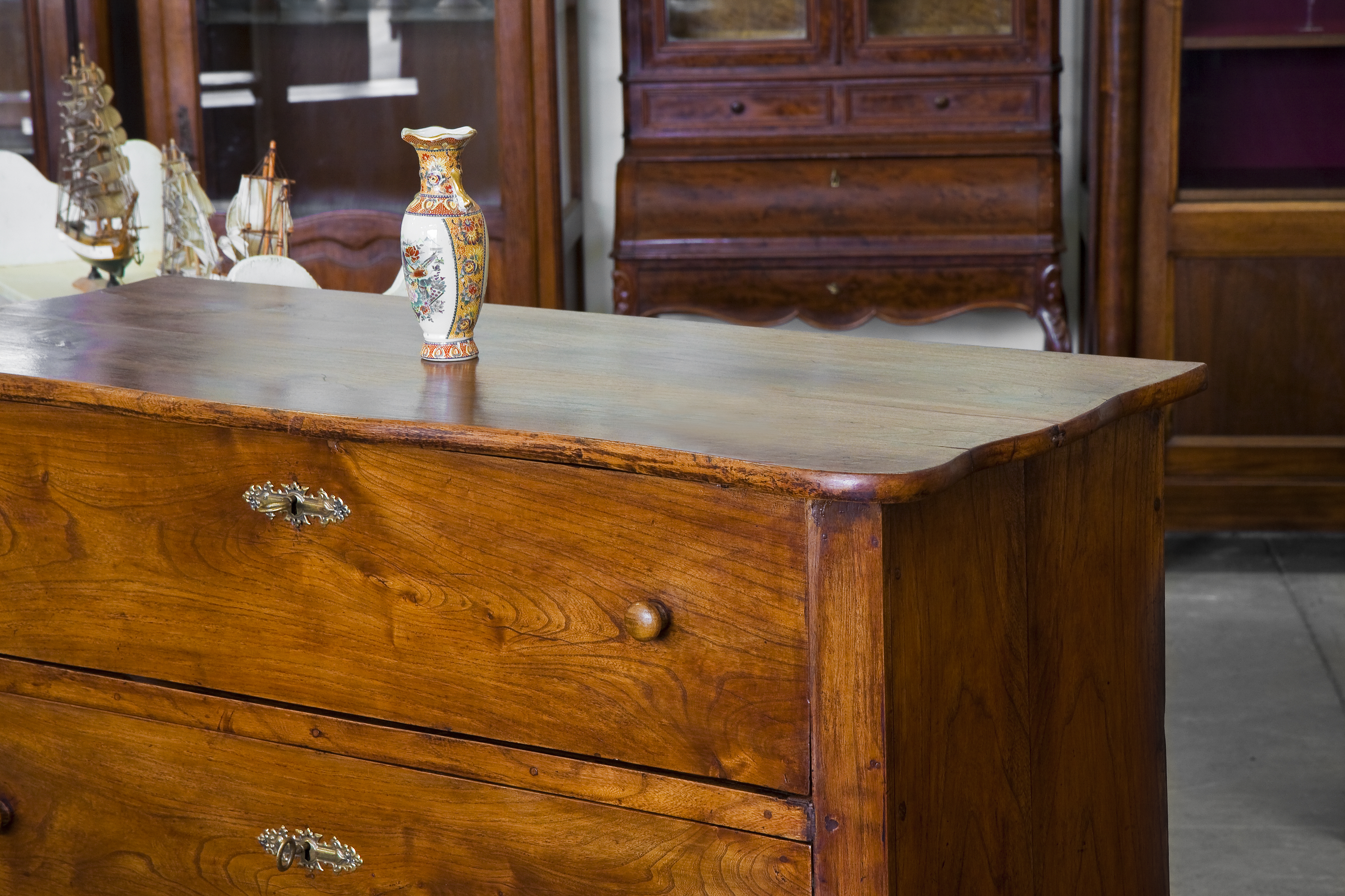 A vase on top of a traditional-style wooden bedroom chest of drawers 