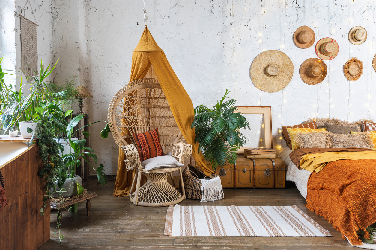 Boho bedroom with plants, a chair, and a bed 