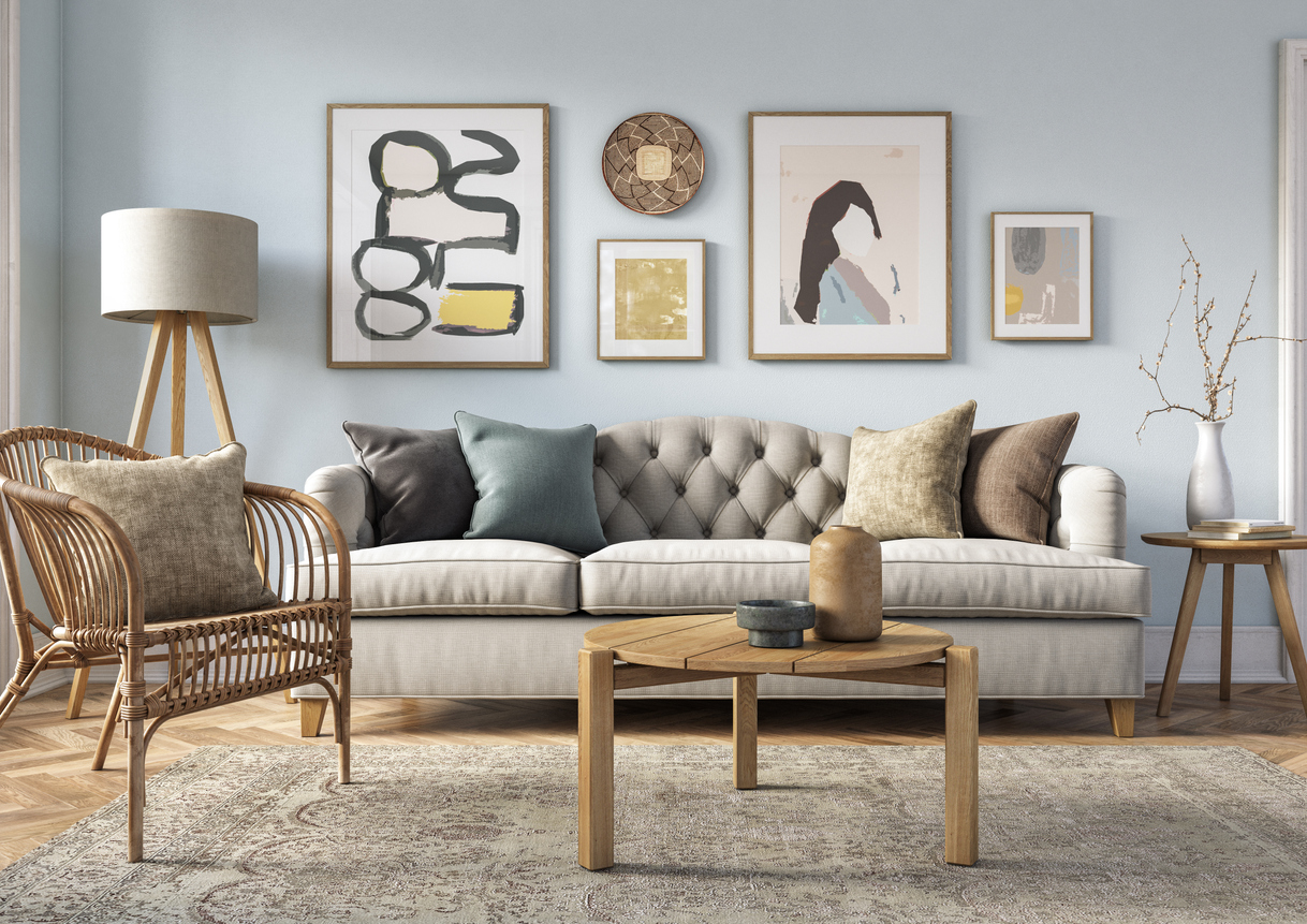 Bohemian living room interior with beige furniture, wooden elements and light blue colored wall