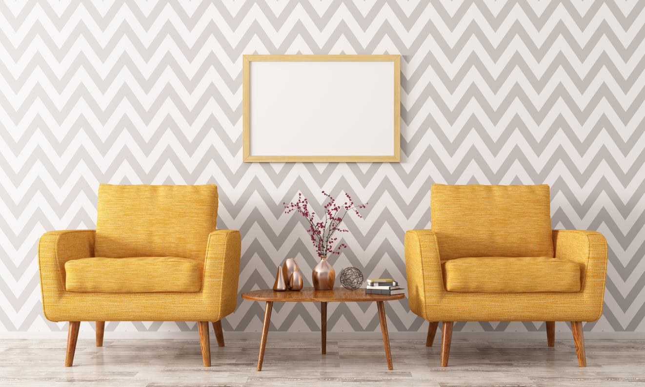 two yellow chairs and a coffee table staged in front of chevron patterned wall 