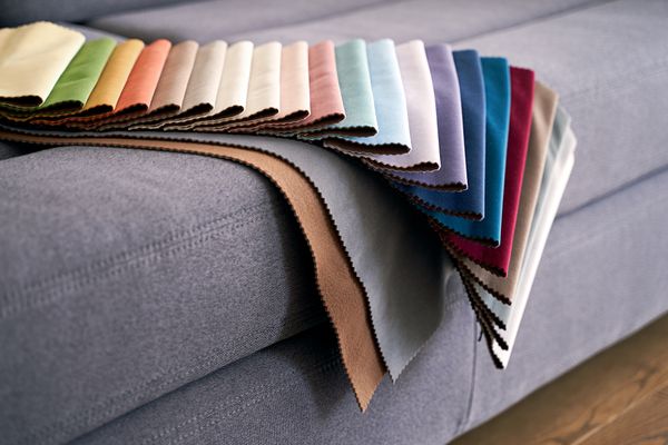 Various fabric color samples on a gray sofa 