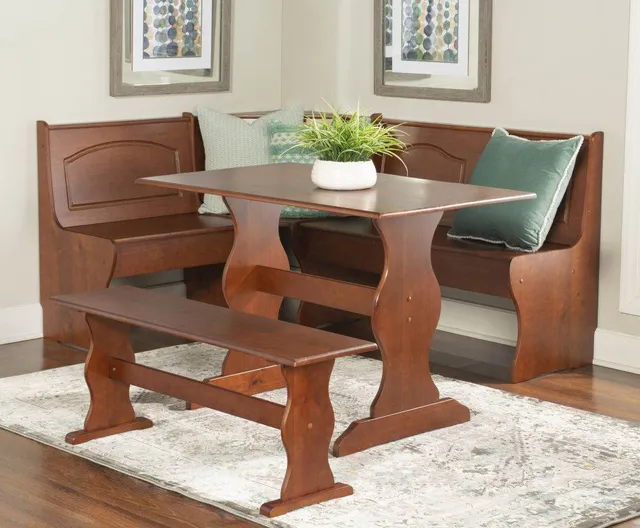 The Linon Chelsea collection 3-piece walnut breakfast nook with green throw pillows 