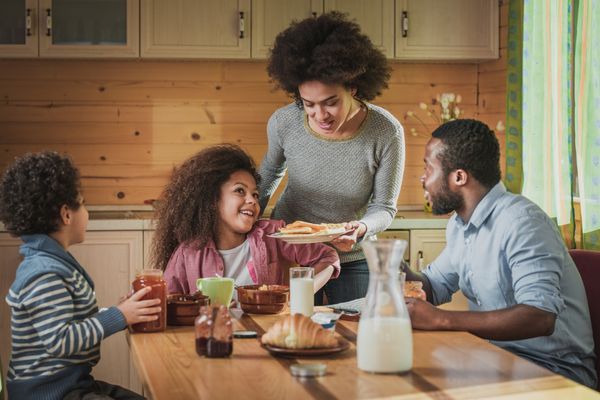 A family of four enjoying breakfast at a table 