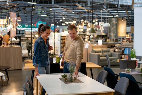A man and a woman reviewing a dining set in a store 