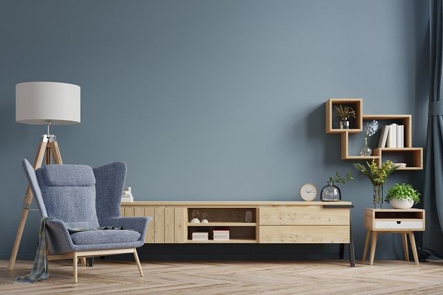 Modern interior of a bright living room with armchair on empty dark wall.