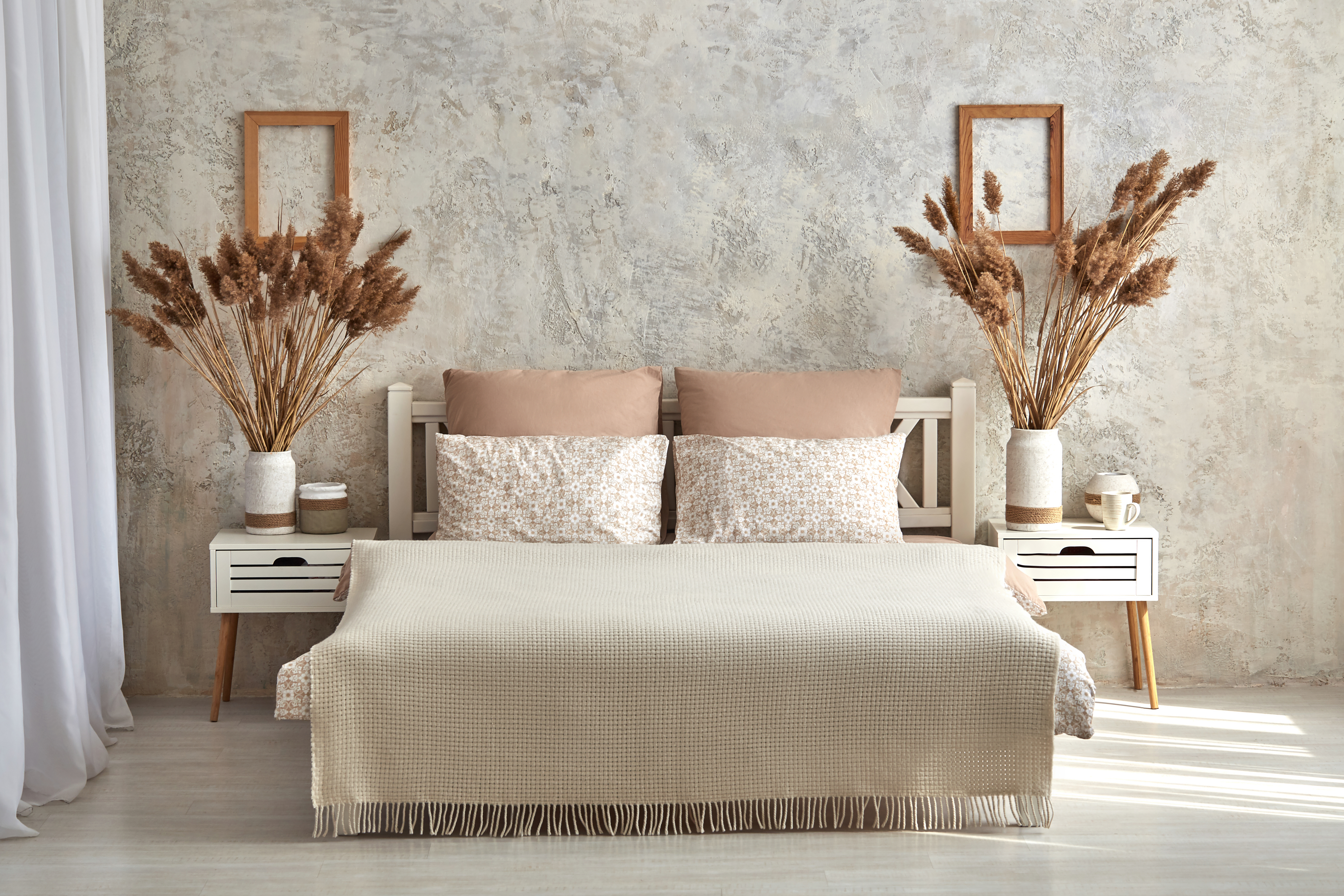 A wide view of a bed with two matching nightstands 