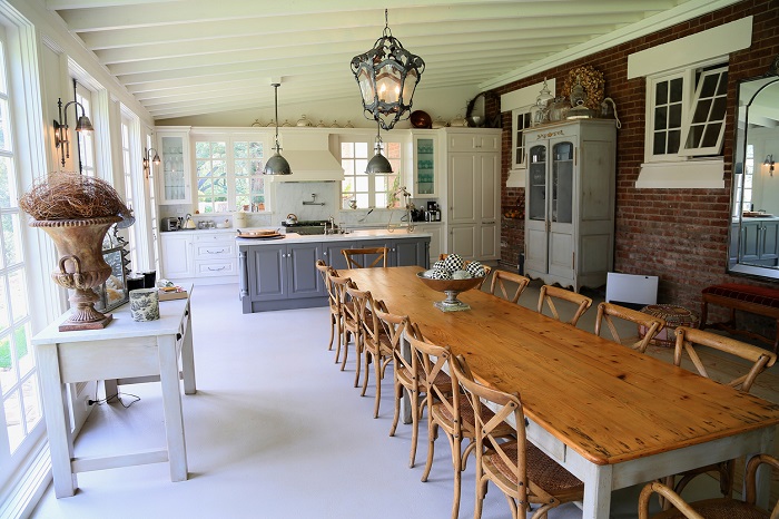 Large farmhouse style dining room with long wooden table.