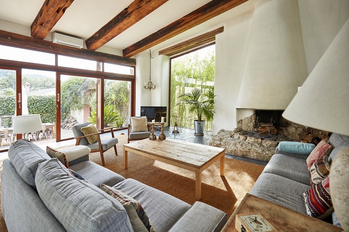 Farmhouse style furniture in a living room with fireplace and exposed beams