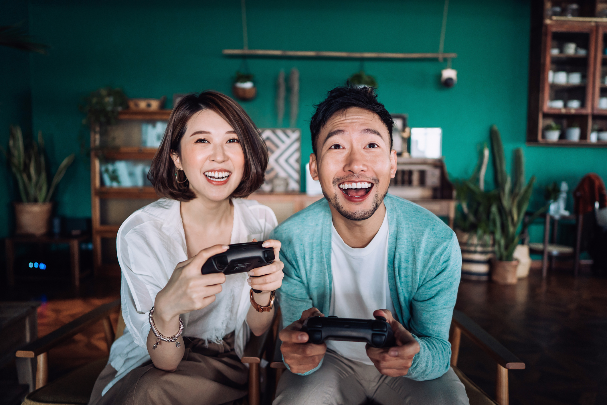 A young couple smiling while playing video games 