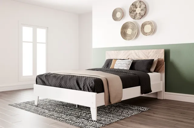 The Signature Design by Ashley Piperton queen bed with griege, green, and black bedding and décor 