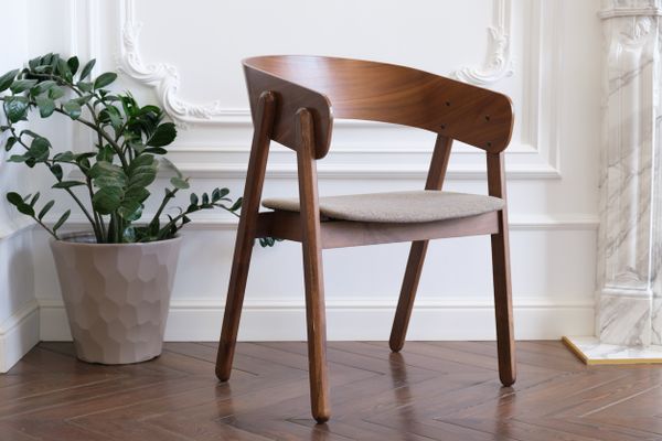 An upholstered wooden club dining chair with décor 