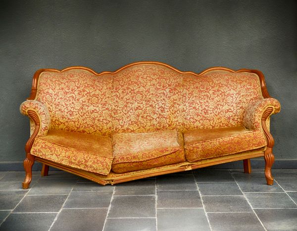 A Victorian era sofa with a broken frame 