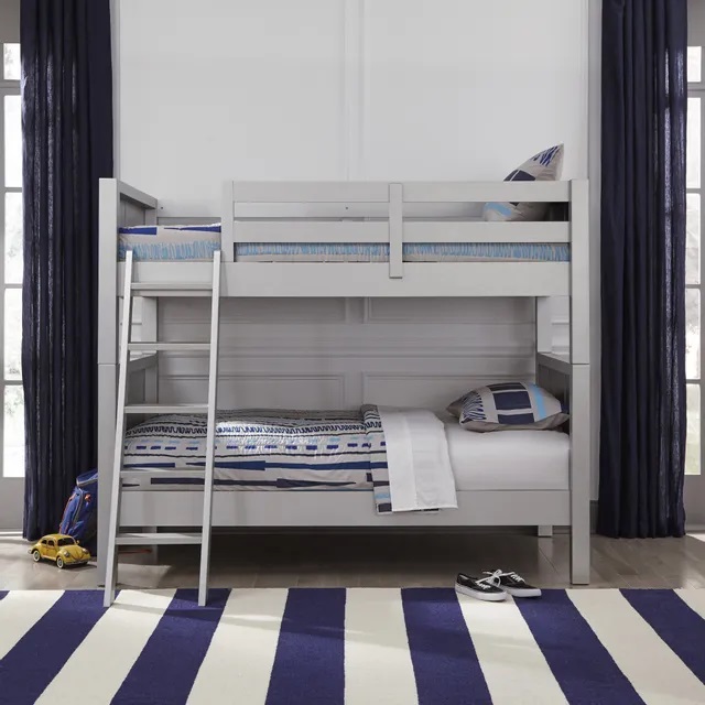 Children’s bedroom with a gray bunk bed and blue and white striped rug. 
