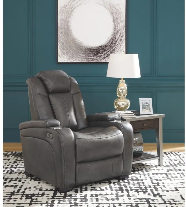 A grey tv recliner in a room with blue walls