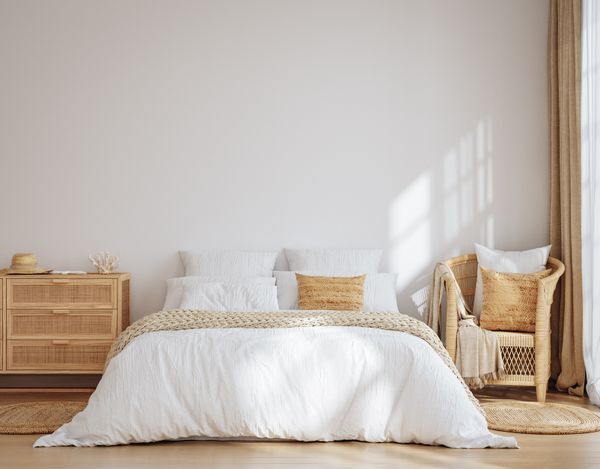 A bedroom featuring wicker furniture with white décor 