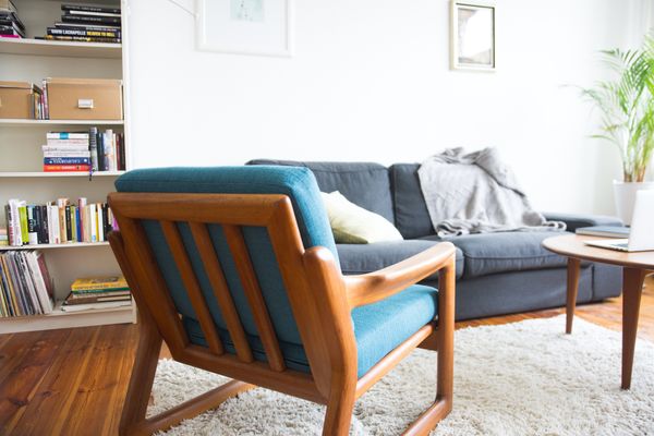 A living room featuring a modern mission style chair with a blue cushion 