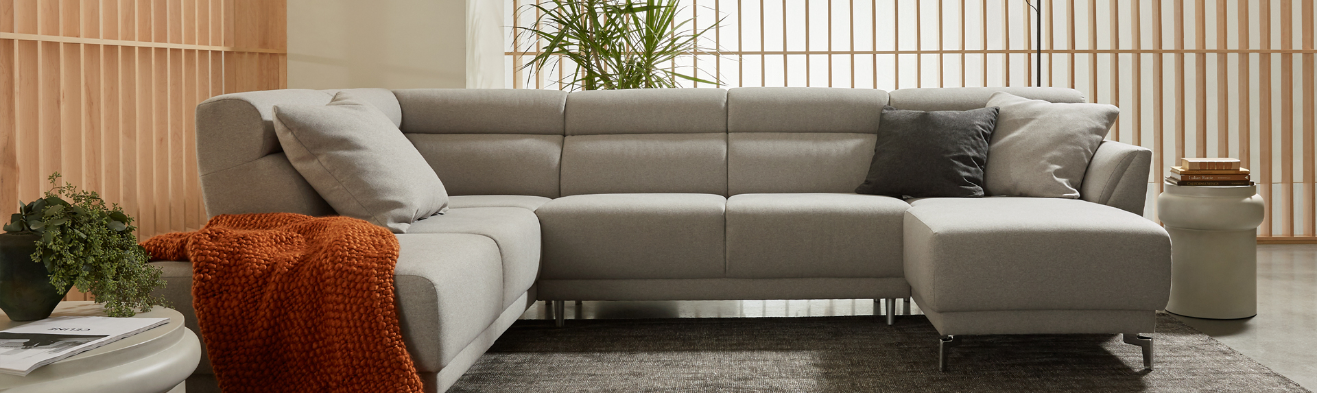 Contemporary living room with wooden framework in the back and a Palliser sectional sofa sitting in the middle. 