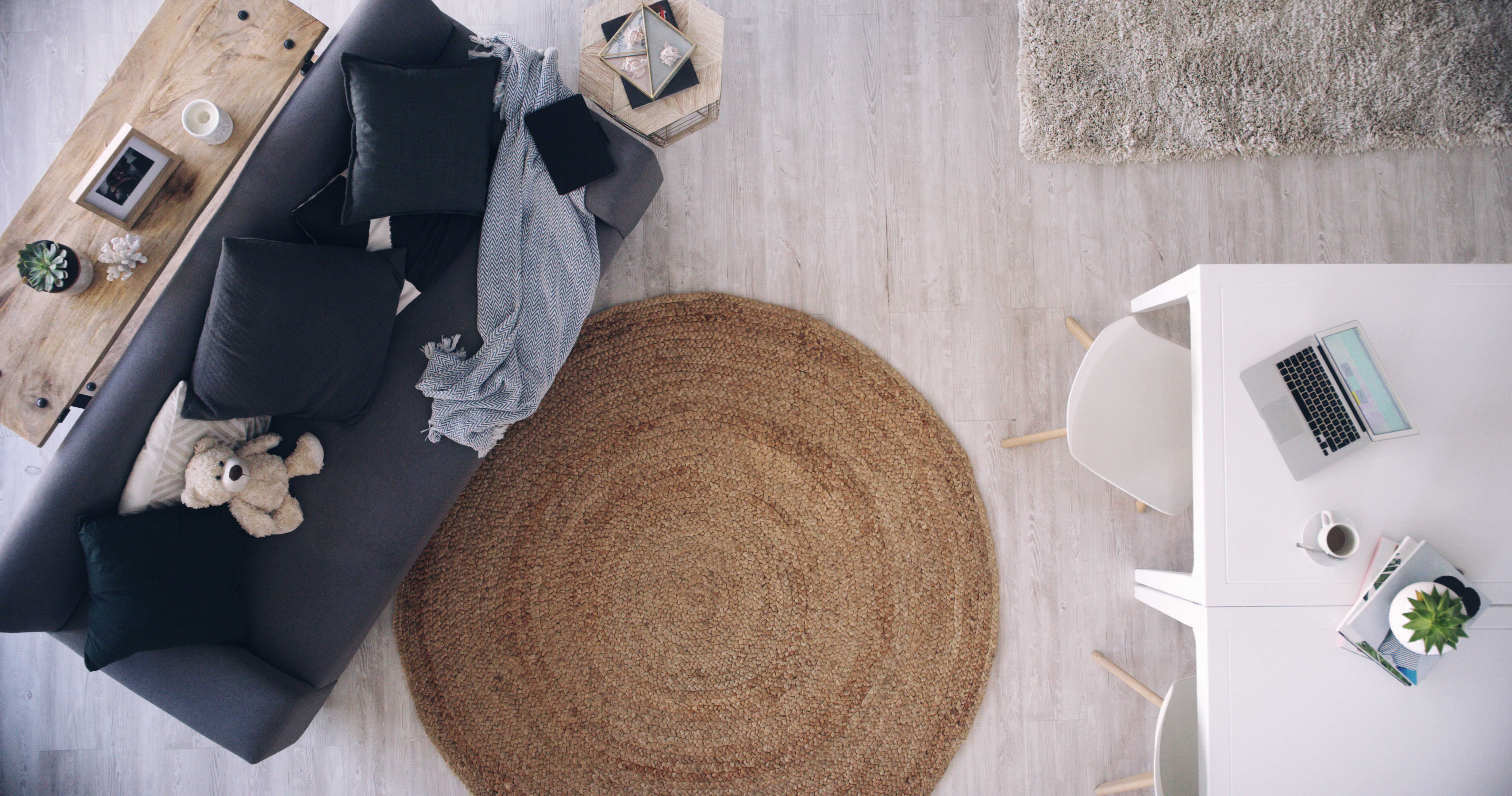 Overhead view of a living room with a blue sofa and a round jute rug 