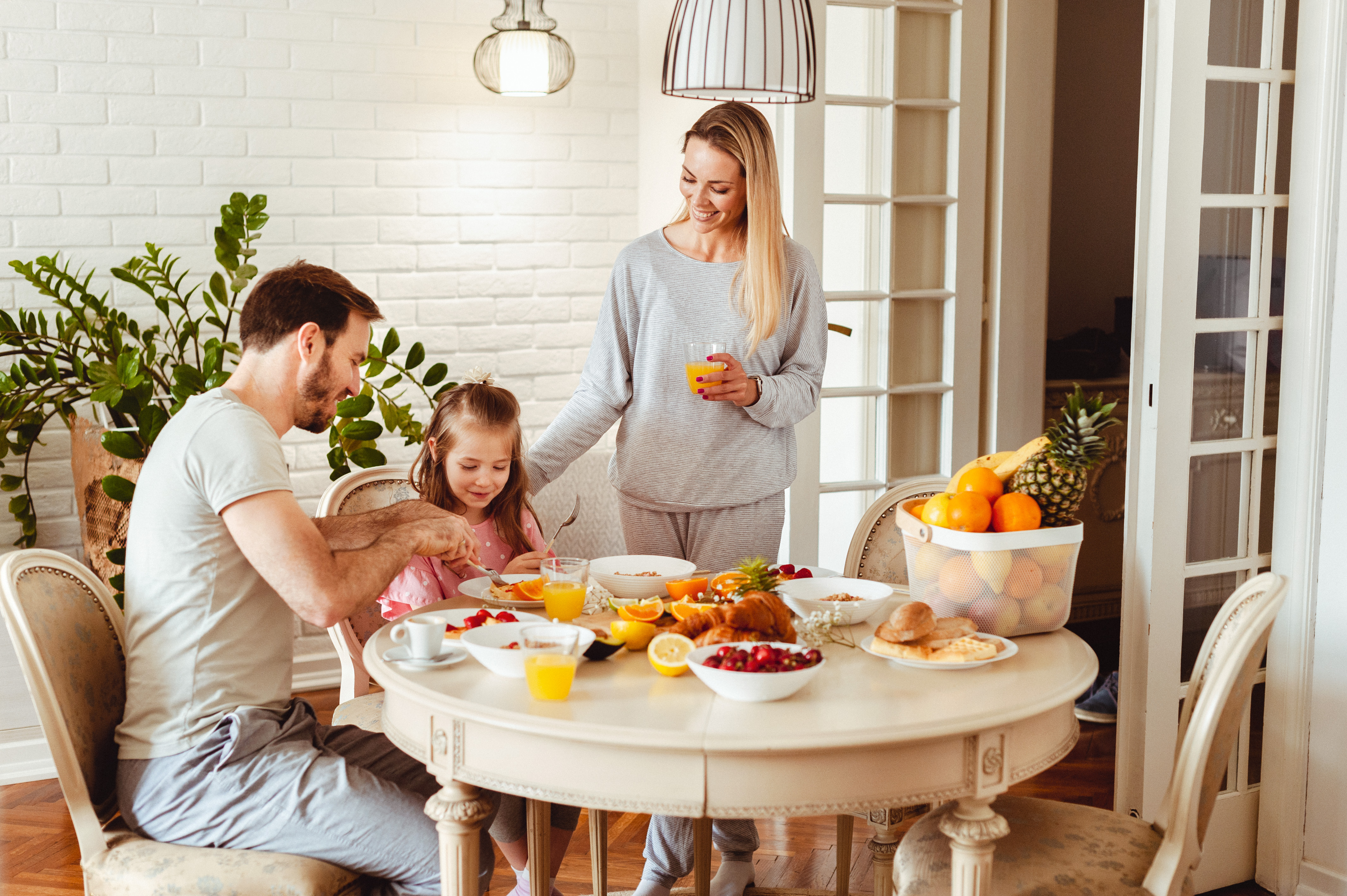 A mother, father, and daughter gathered around a round table 