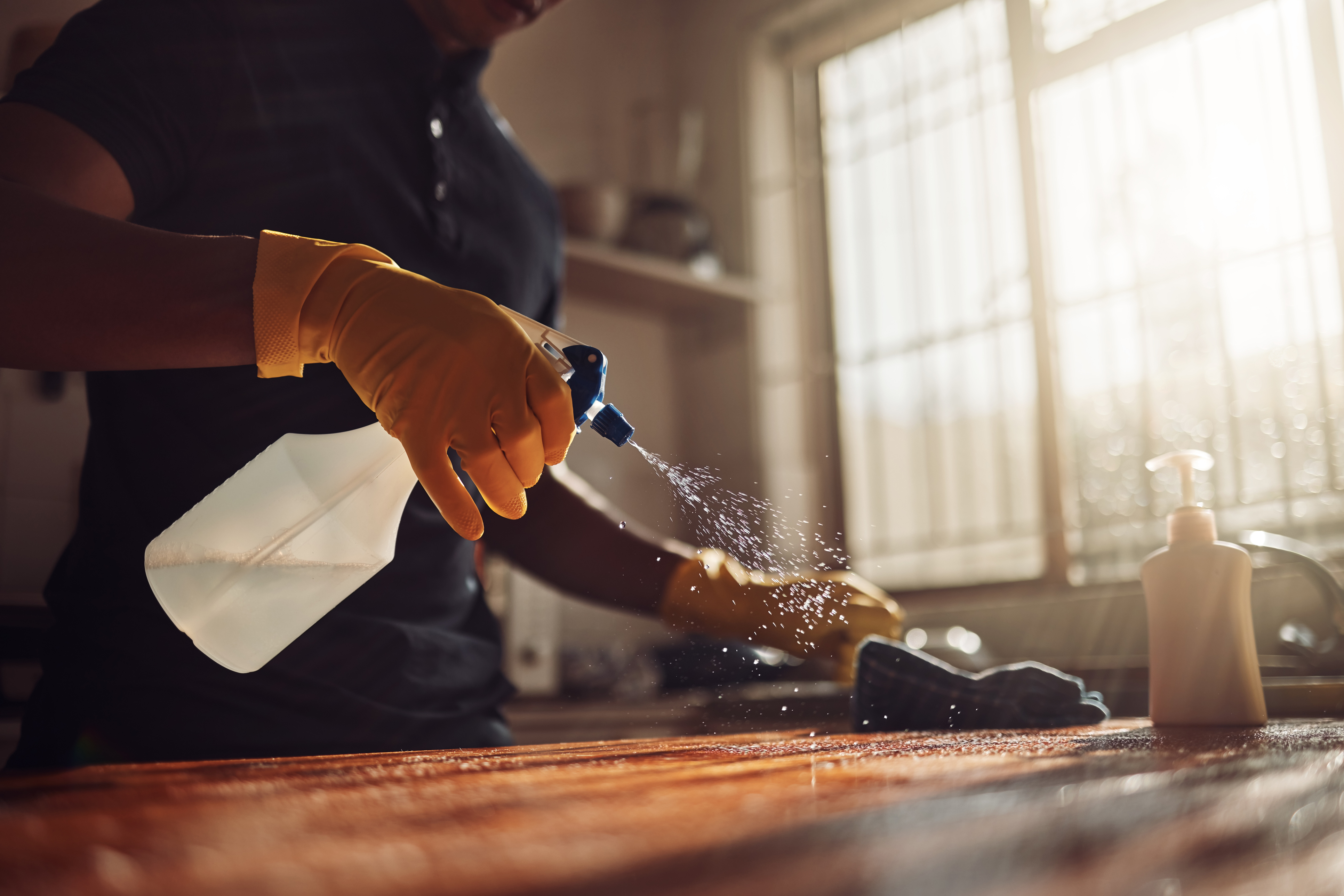 A person cleaning a solid wood surface 