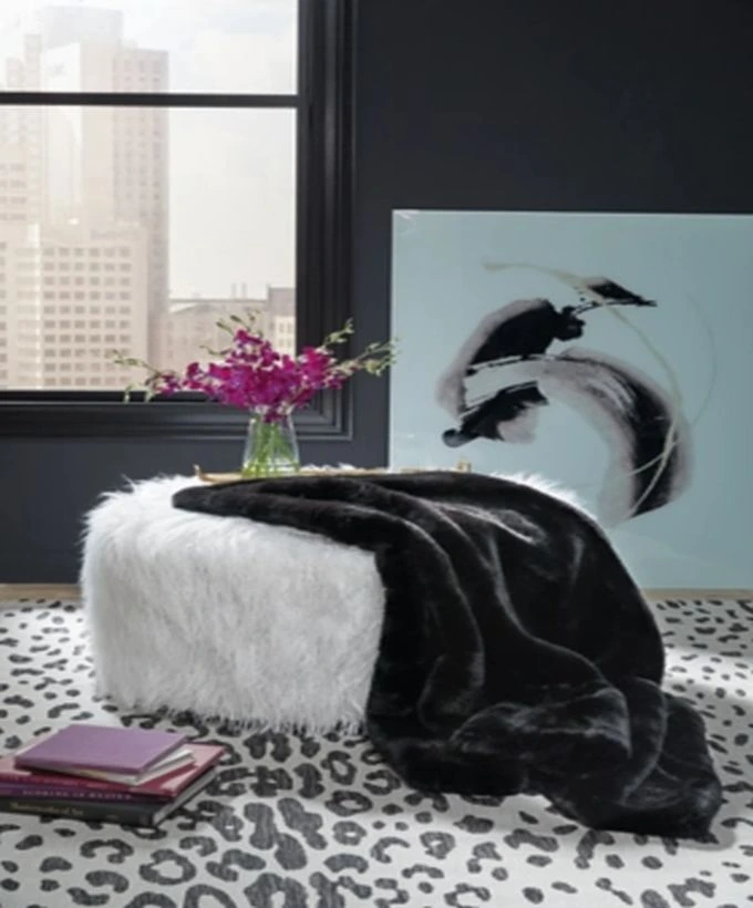 The Signature Design by Ashley Gariland black throw pillow on a pouf 