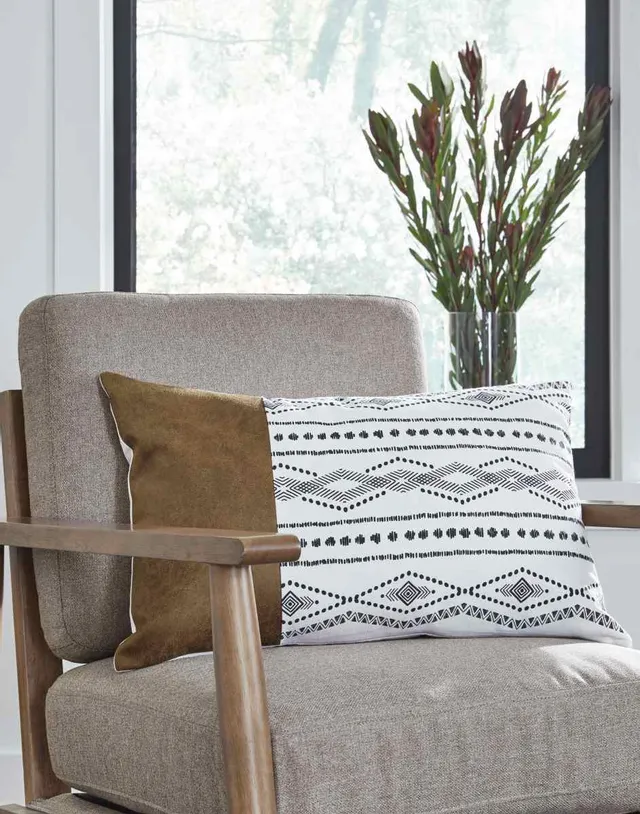 The Signature Design by Ashley Lanston throw pillow on an accent chair 