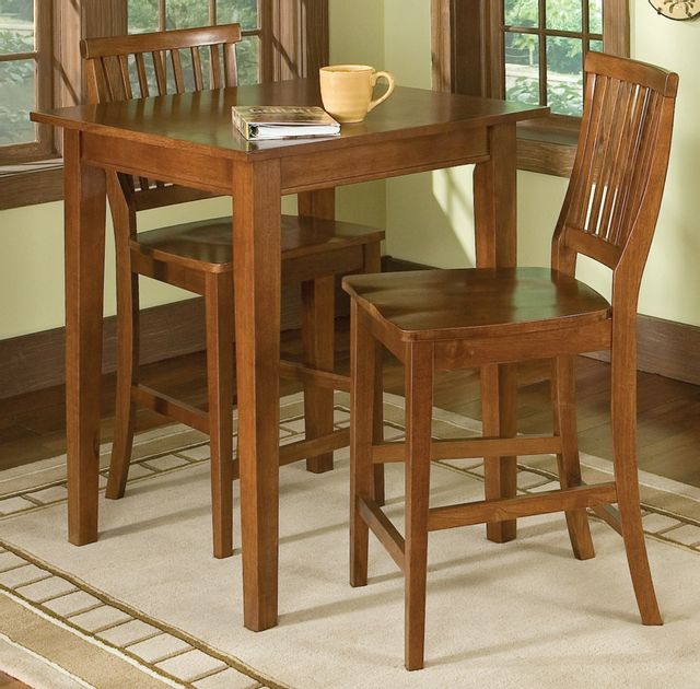 High rise wooden table with mug and book sitting on it with two wooden chairs on each side.  