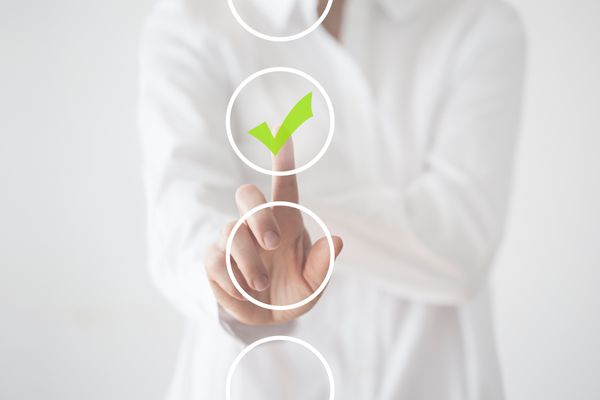 A person pressing a green checkmark graphic 