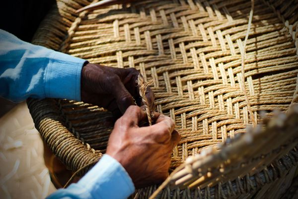 A man weaving wicker out of natural fibers  