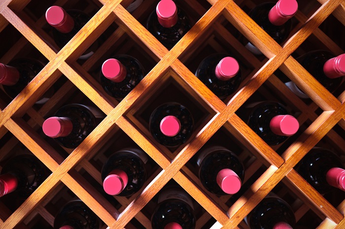 Close up of wine bottles being stored in a wine cabinet. 
