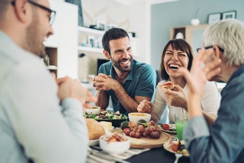 Family Laughing Together at Dining Table