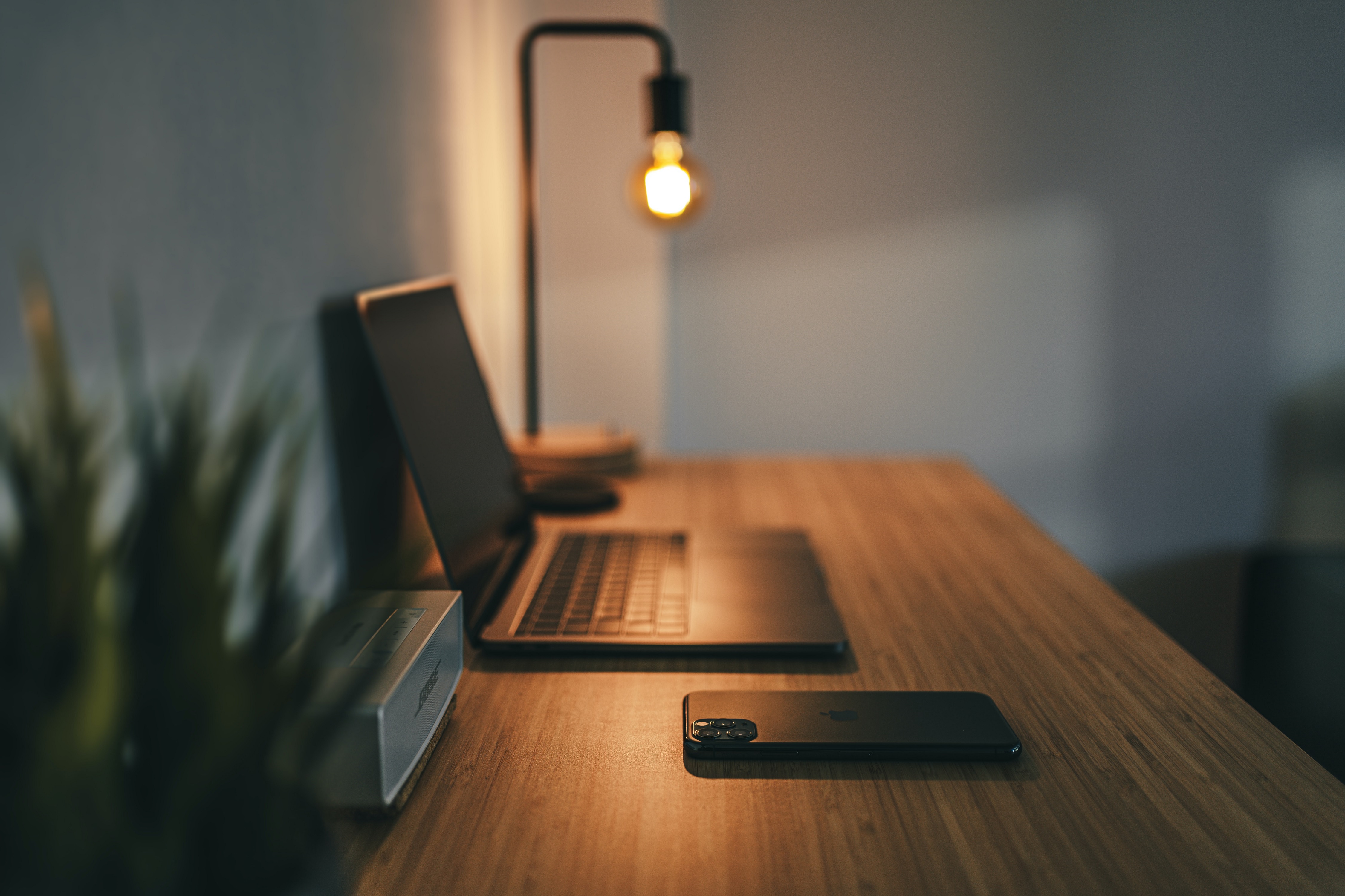 industrial desk lamp illuminates corner of oak desk