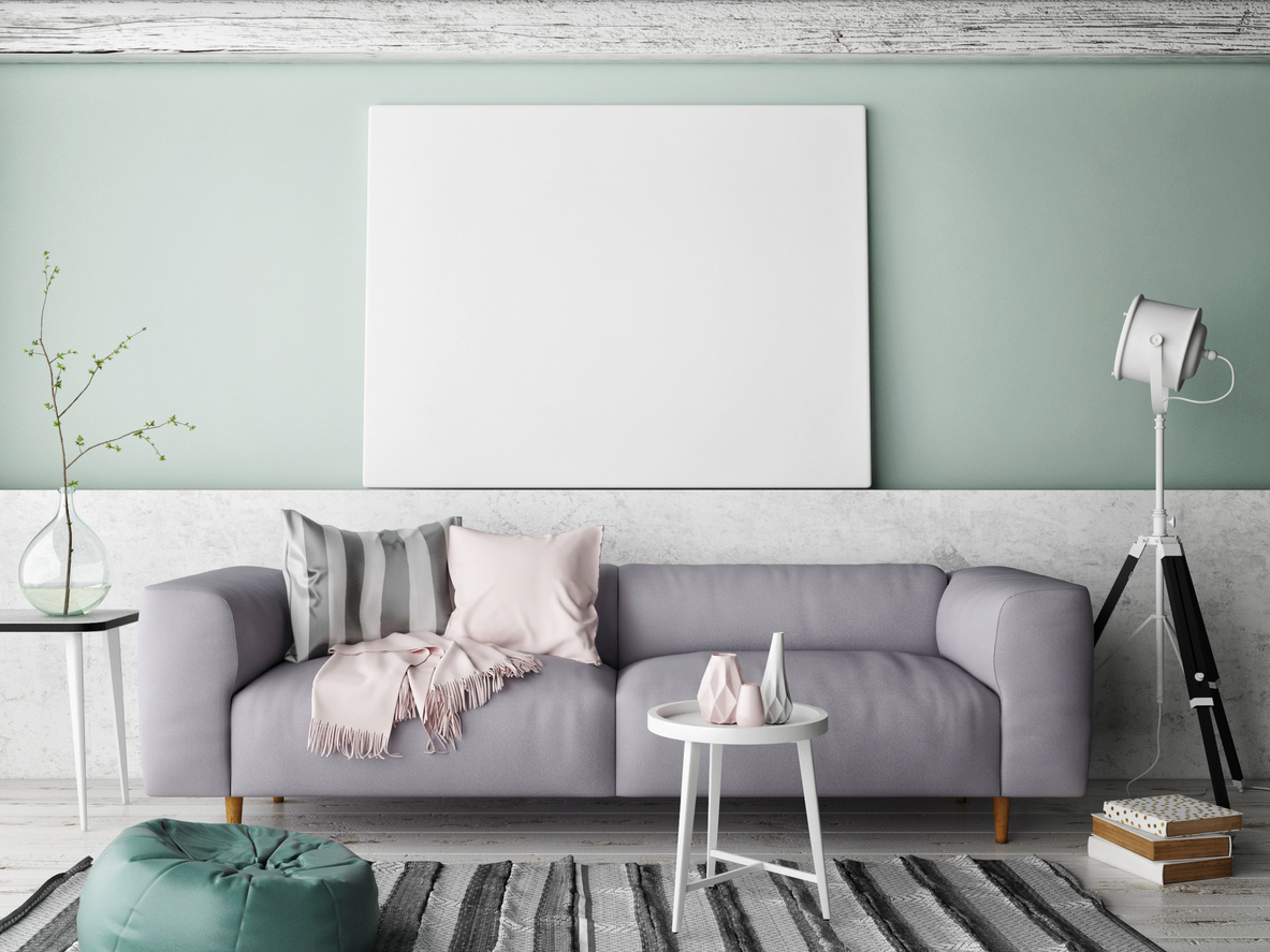 Modern living room with large gray couch and mint background.