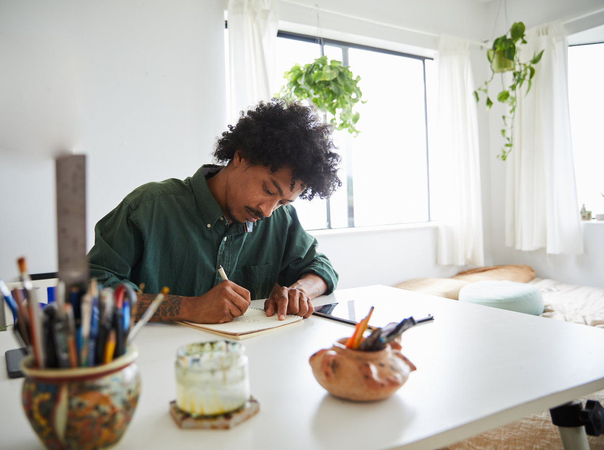 Young man works from his home office in a bedroom