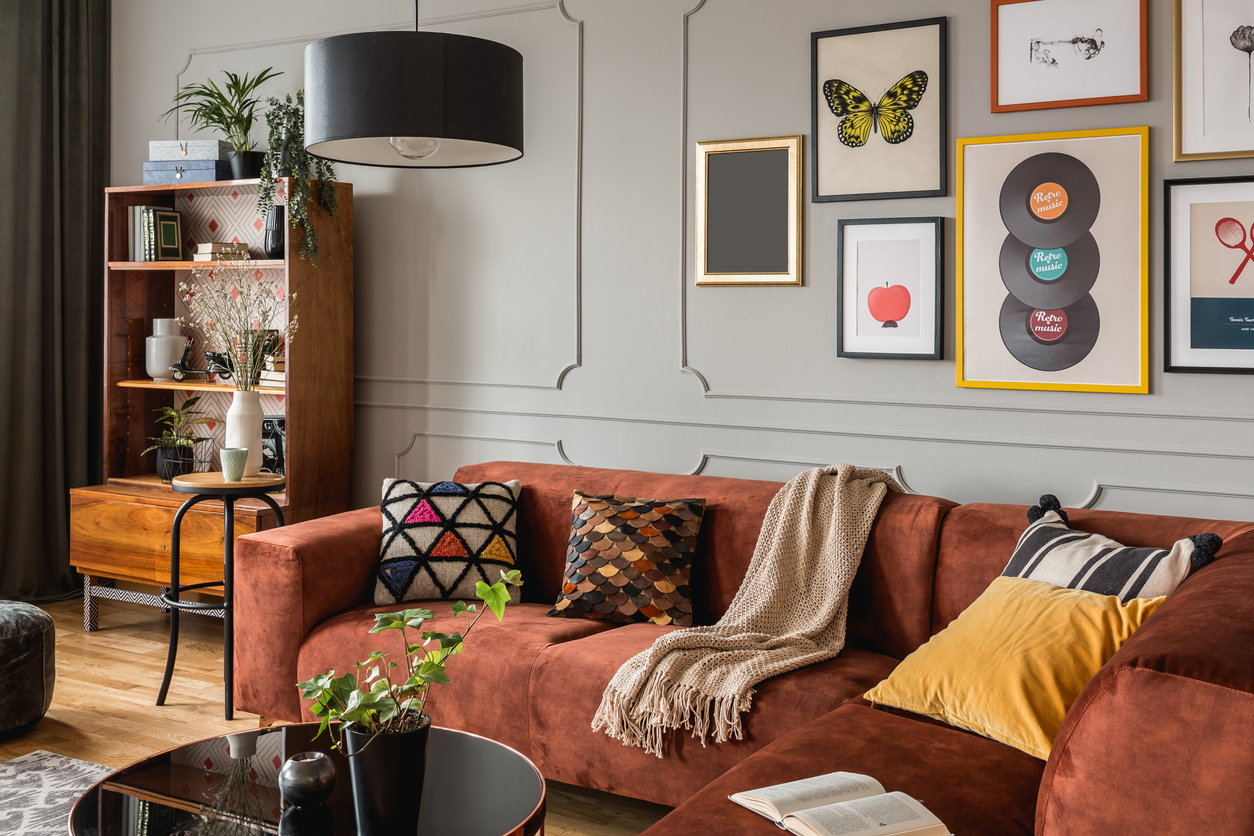 gallery of trendy posters in elegant grey living room interior with brown corner sofa