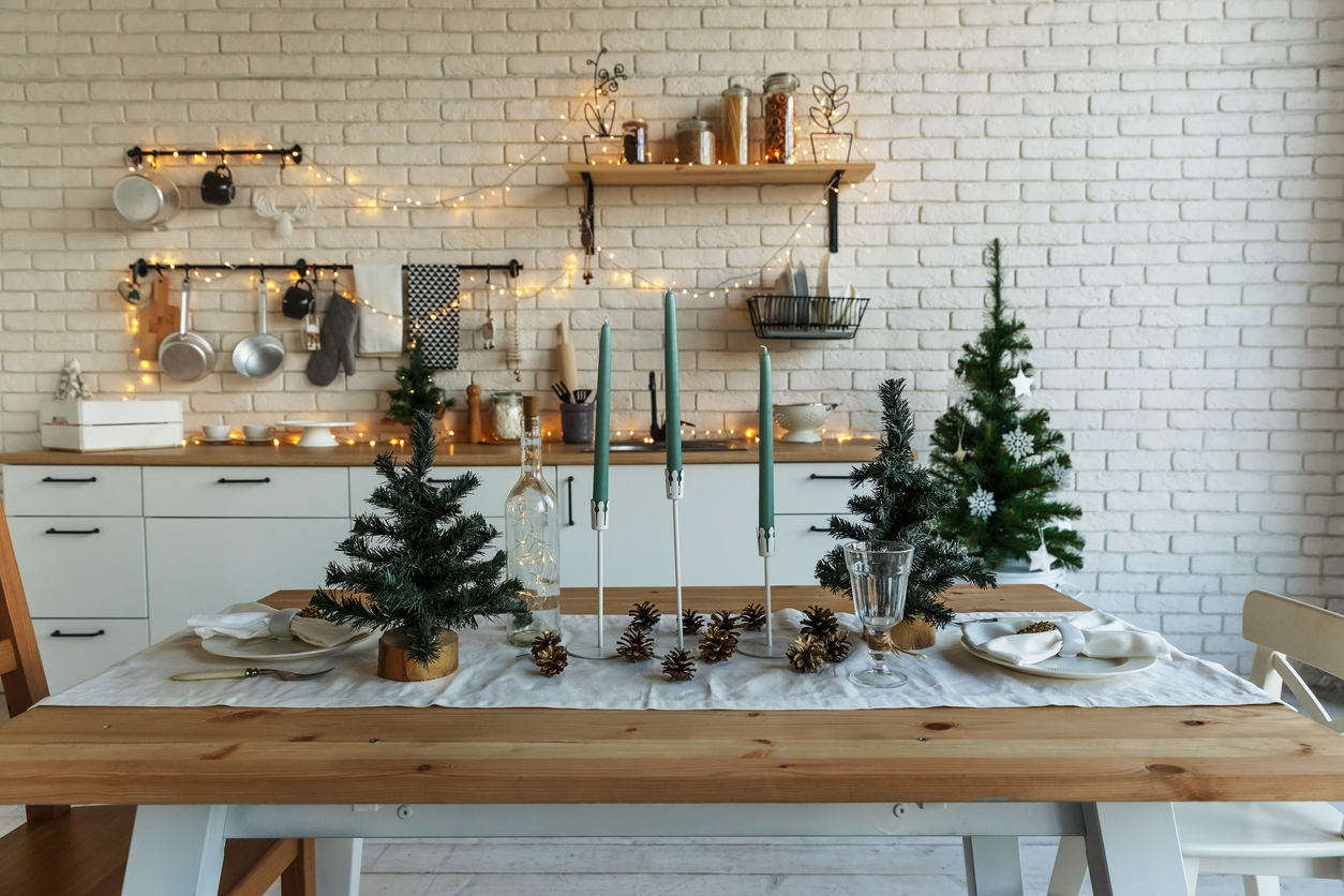 hip white kitchen with rustic pinecones and Christmas tree tabletop decorations