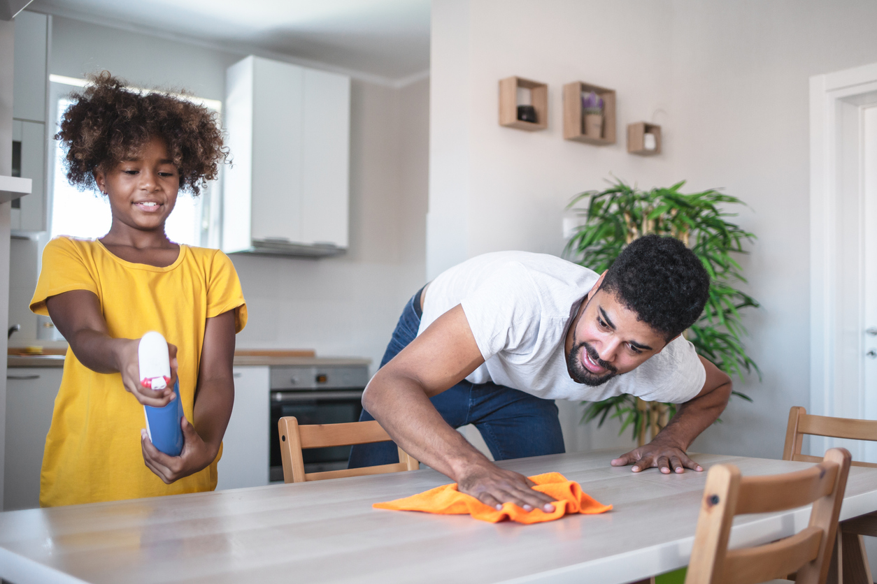 daughter and father cleaning dining table together