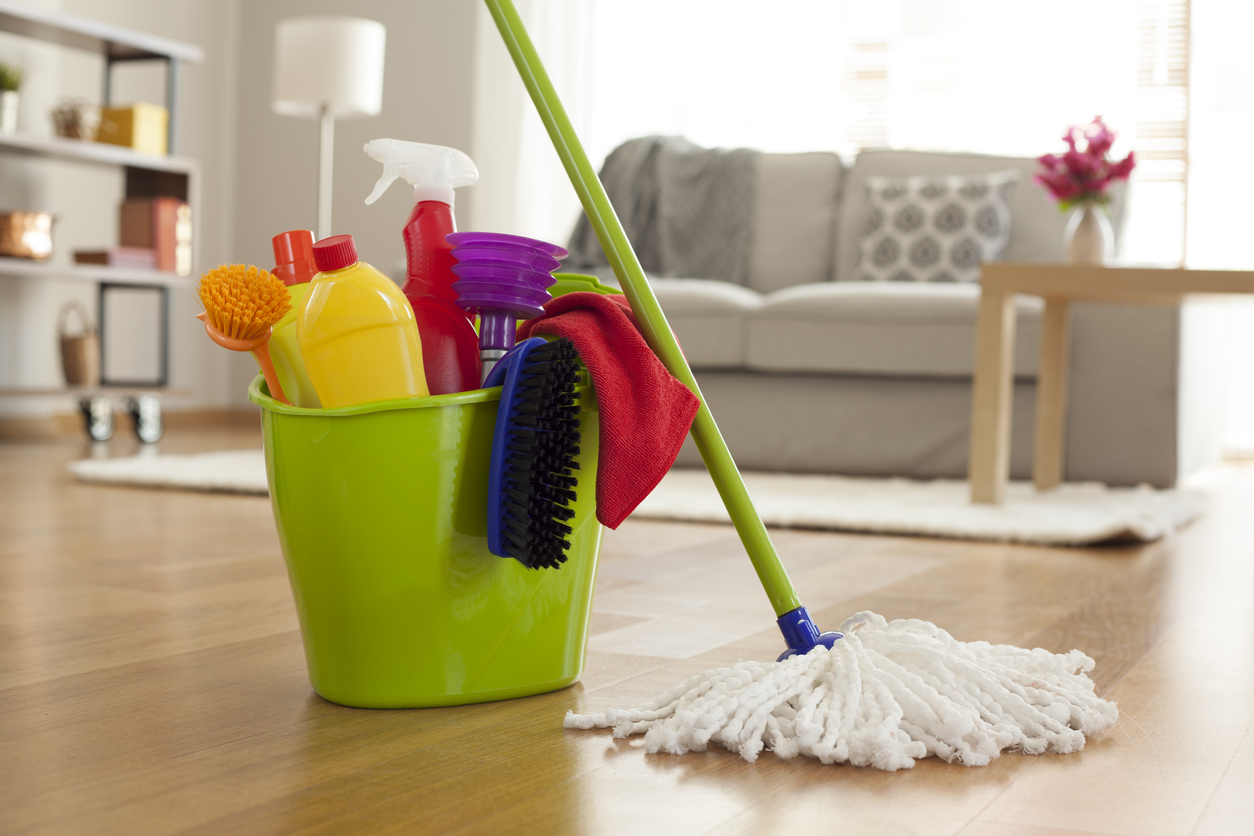 plastic bucket with cleaning supplies in living room