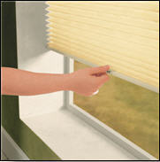 woman pulling down pleated shades