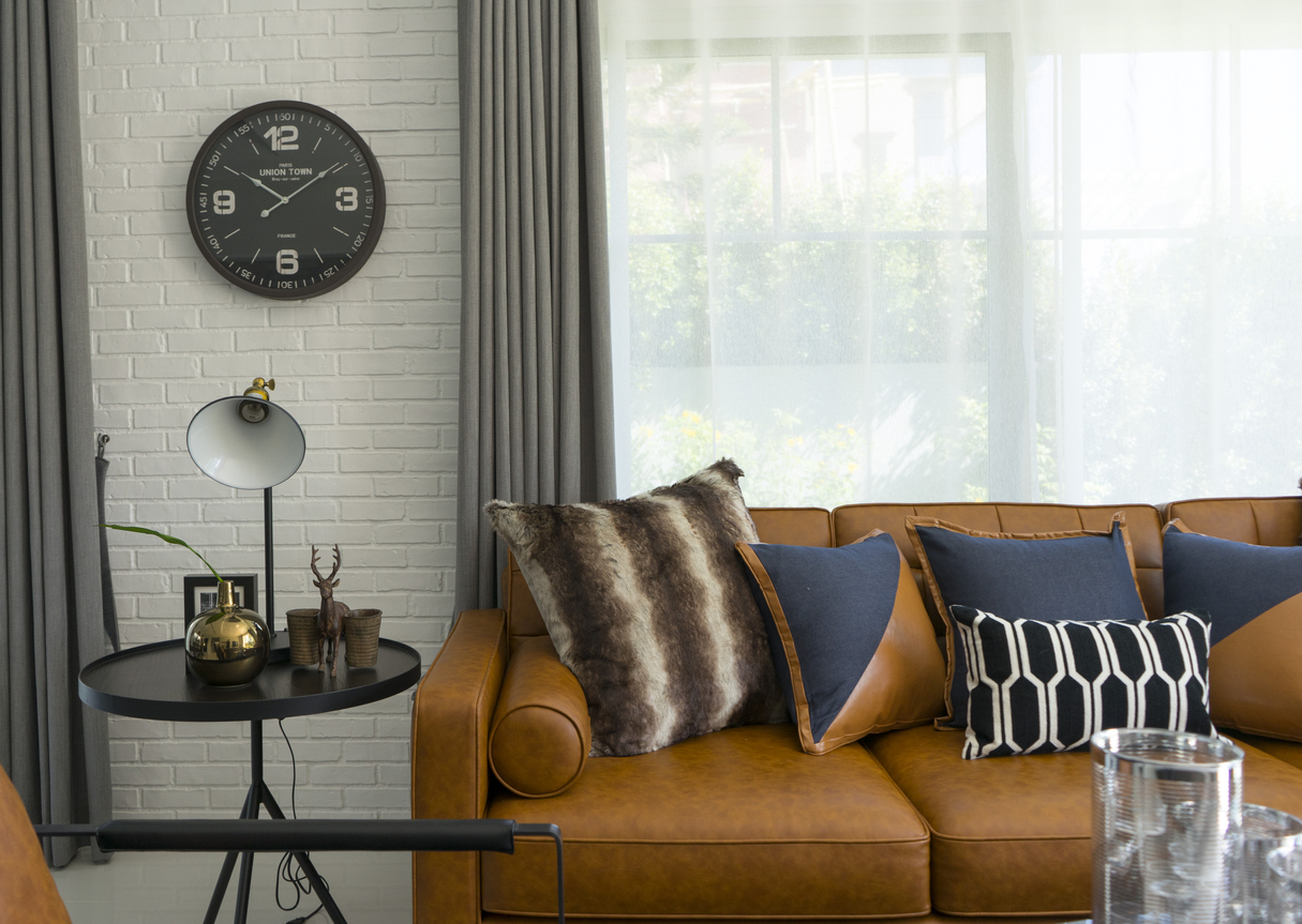 brown leather couch with bohemian-style throw pillows