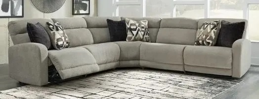 Image of a modern living room with a white and grey accent rug and a gray l shaped sectional sofa. 