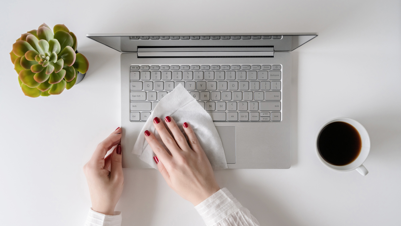 woman cleans laptop with antivirus wet wipe