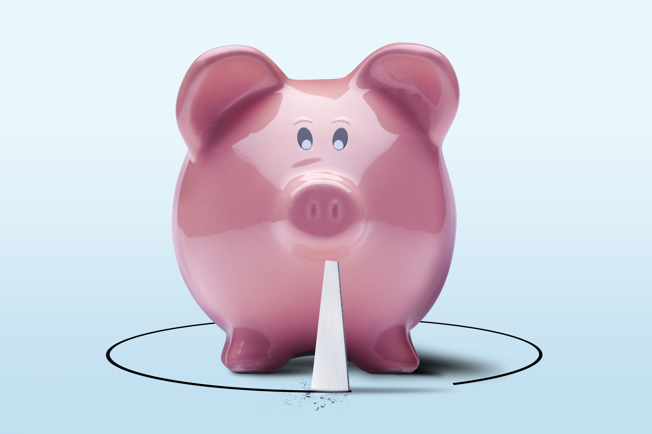 A pink piggie bank being sawn away from below 