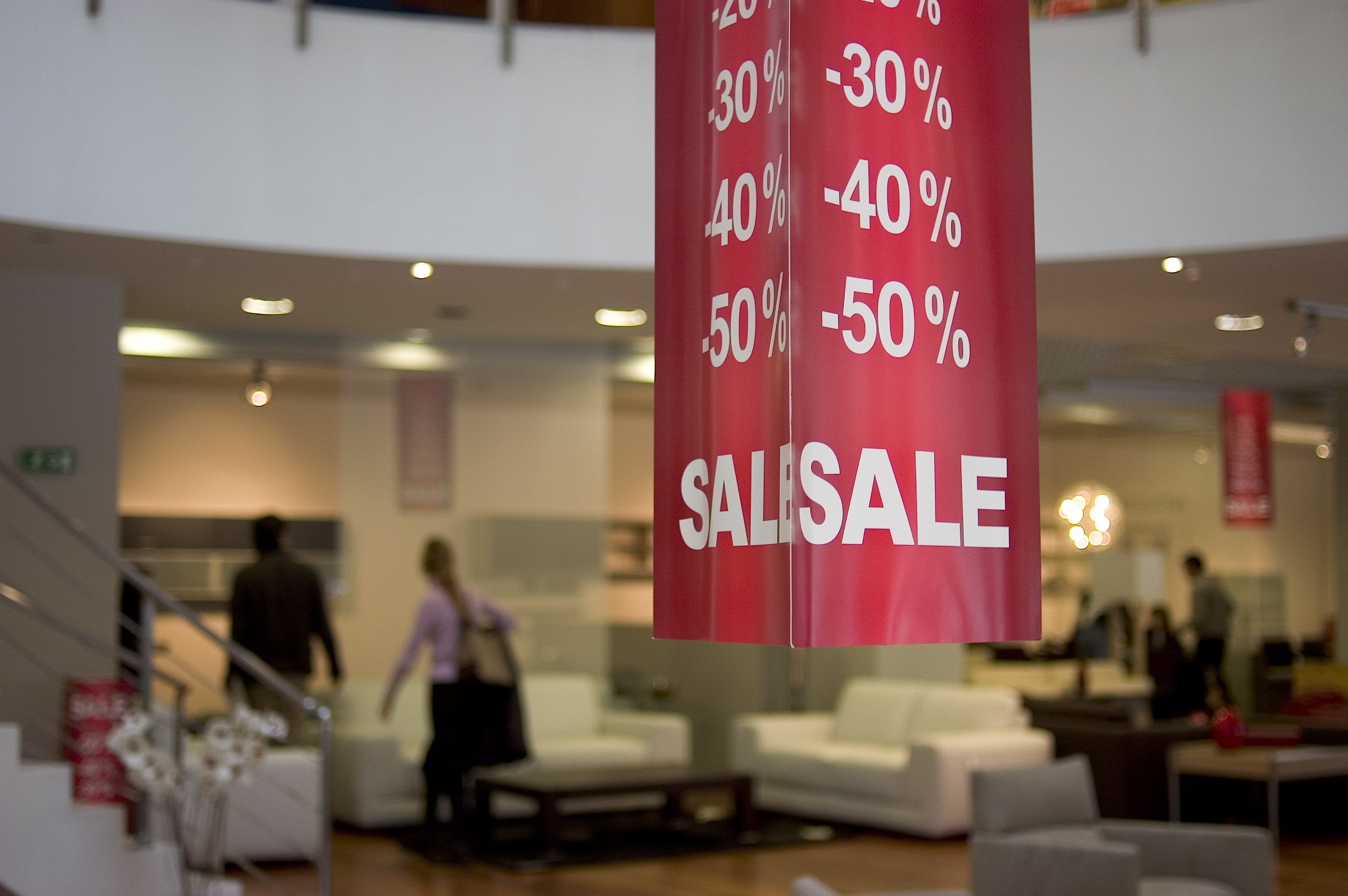 A sale sign handing with a furniture store in the background 