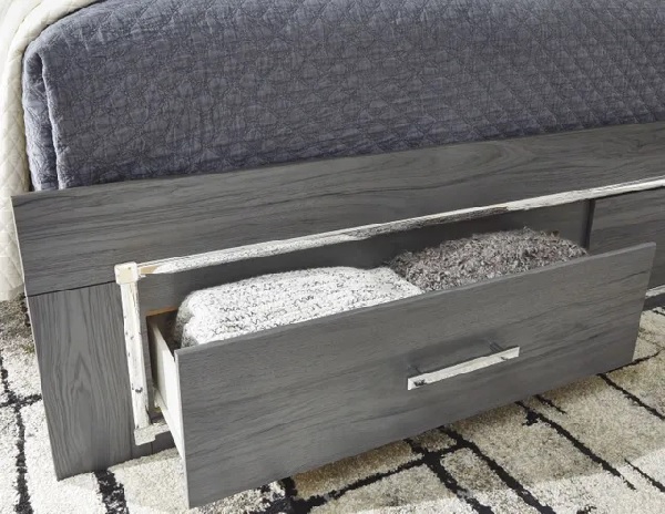 A close-up of items inside the Signature Design by Ashley Lodanna collection storage bed drawer 