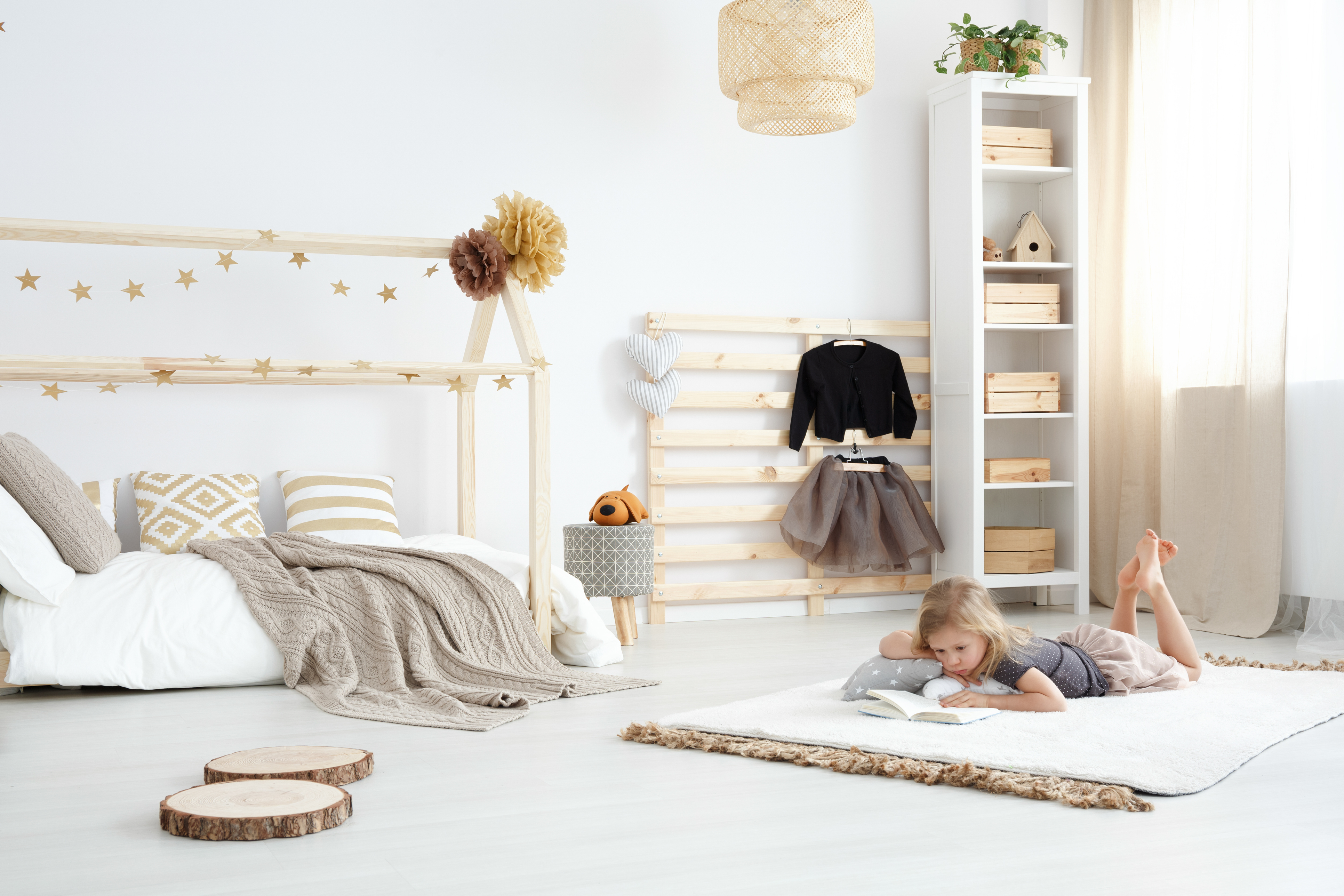 A girl reading in a farmhouse kids’ bedroom 