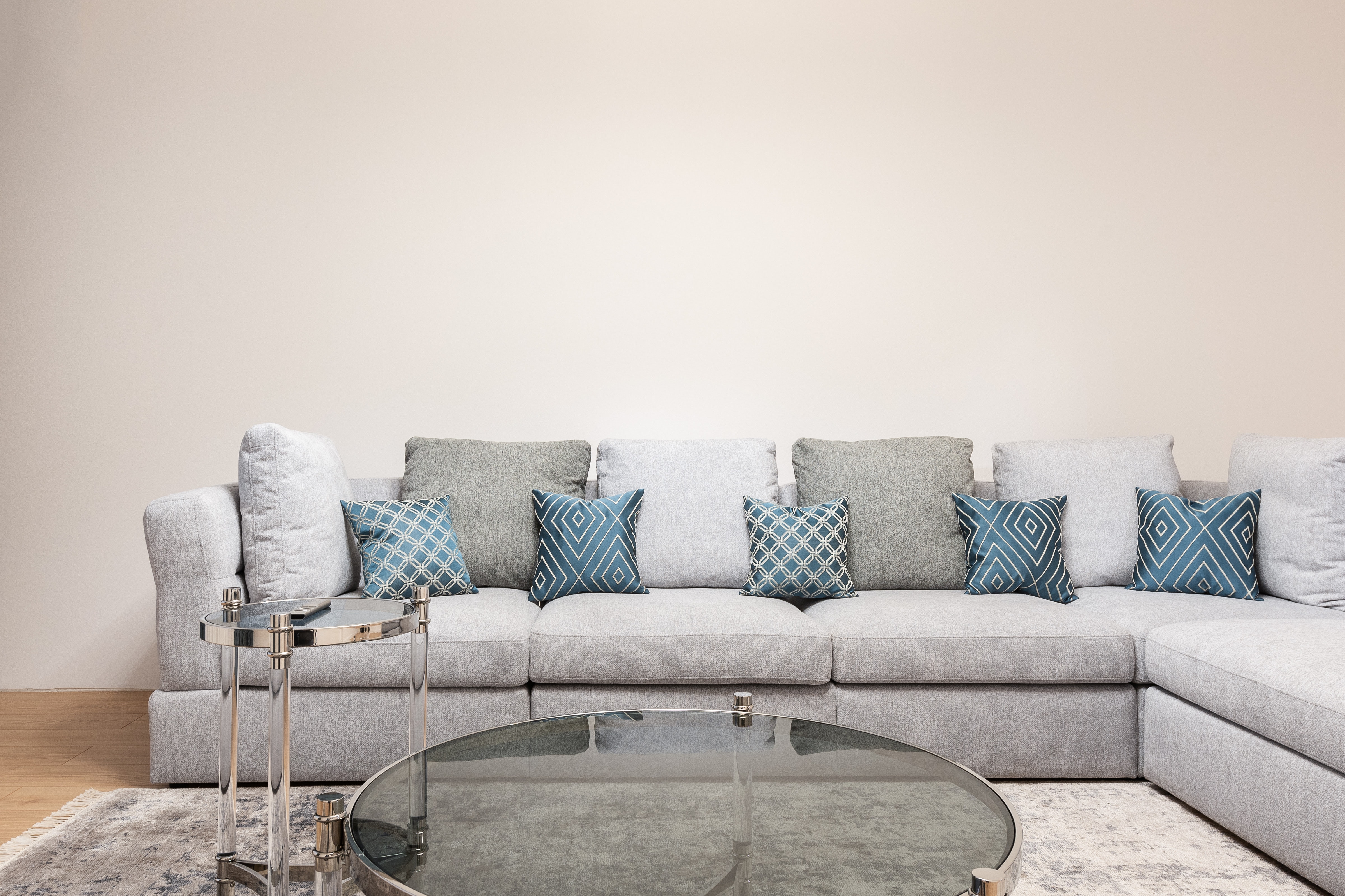 A grey L-shaped sectional with blue accent pillows 